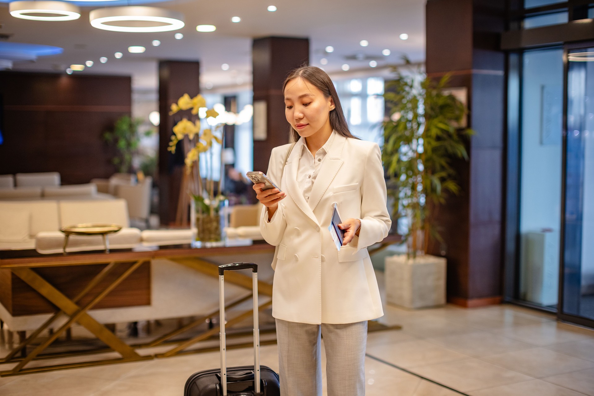 Young businesswoman making a reservation at a luxury hotel lobby while traveling for work